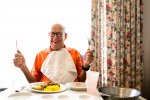 candid-portrait-of-a-happy-senior-man-in-his-90ties-ready-to-eat-lunch-holding-up-his-knife.jpg