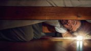 emotional-man-peering-under-the-bed-with-flashlight-and-fearful-eyes-halloween-tension.jpg